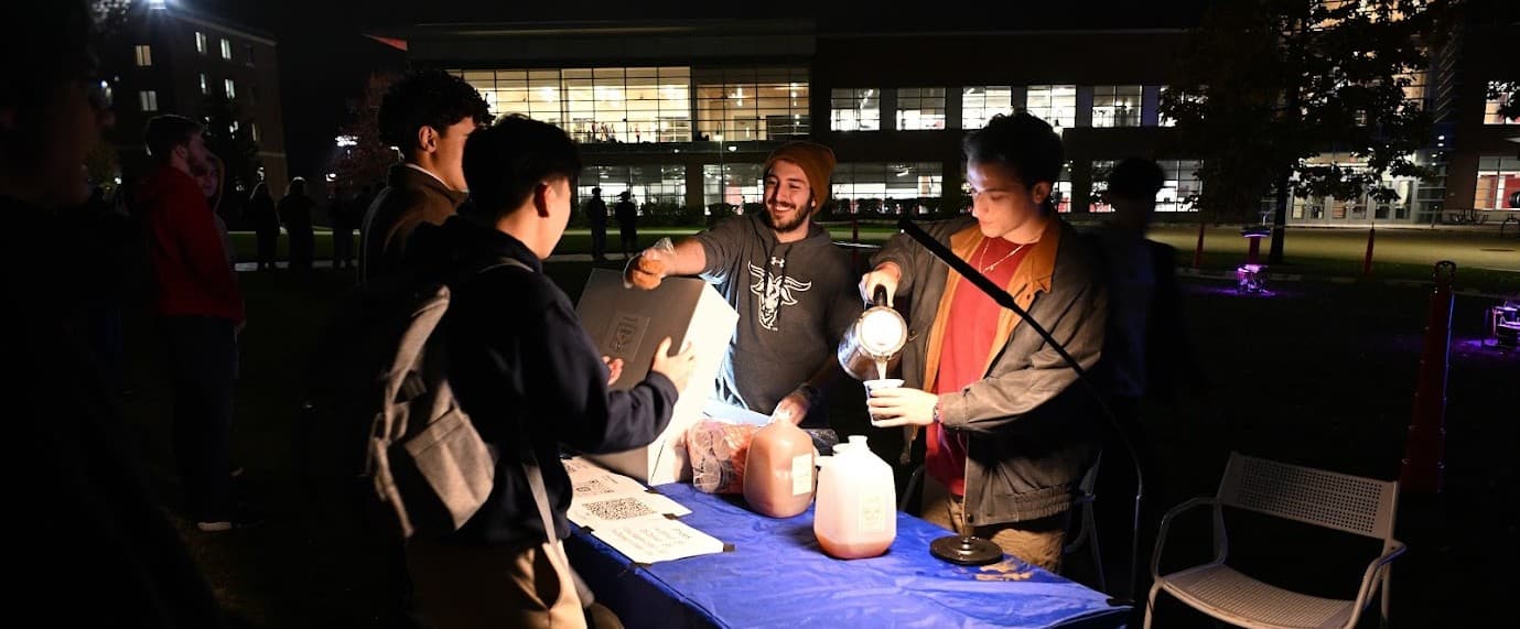 Samuel at the IEEE Sparks student chapter event booth at night